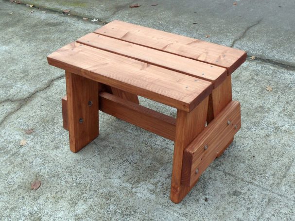 Commercial quality eco-friendly Outdoor Picnic Table Bench slanted to the left on the sidewalk.