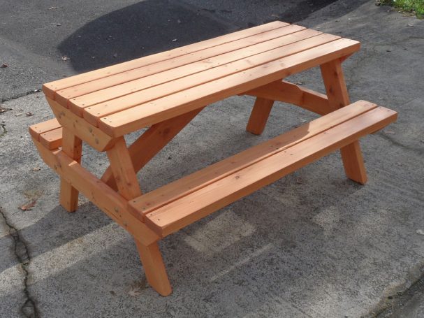 Commercial quality Eco-friendly Outdoor Kids Attached Bench Picnic Table slanted to the right on a sidewalk.