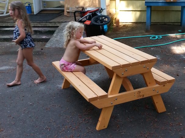 Little girl sitting at a Commercial quality Eco-friendly Outdoor Kids Attached Bench Picnic Table slanted to the left.