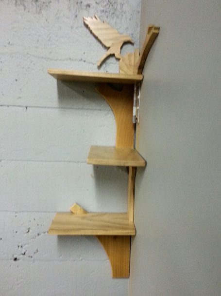 View of the left side of a Handcrafted Poplar Bird and Tree Corner Shelf hanging in the corner.