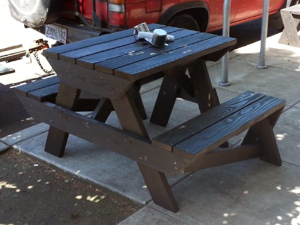 Back of a 4' Commercial quality Custom Eco-friendly Outdoor Hybrid Bench Picnic Table on a restaurant bar patio.