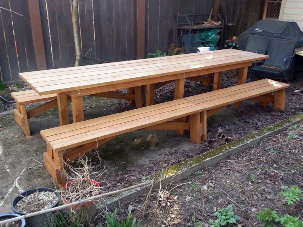Extra-long aproned Commercial quality Custom Eco Outdoor Detached Bench Picnic Table with four benches on a patio.