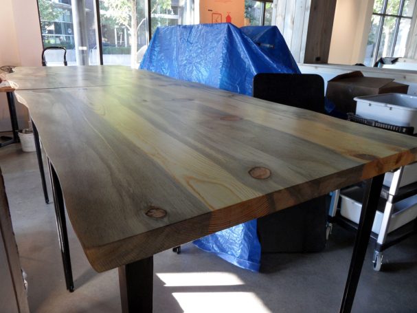 Large commercial quality Blue Pine Live Edge Slab Table Top dining table slanted to the left at a restaurant bar.