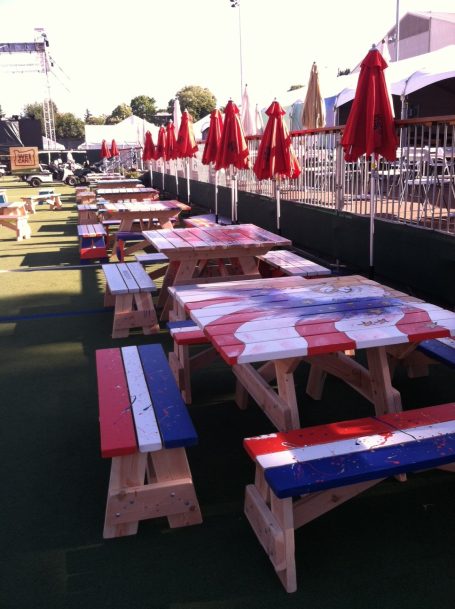 Hand painted Commercial quality Eco Outdoor Square Detached Bench Picnic Tables in a row to the left at an event.