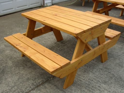Pinewood stain color option on a 4' Commercial quality eco-friendly Outdoor Attached Bench Picnic Table on a sidewalk.