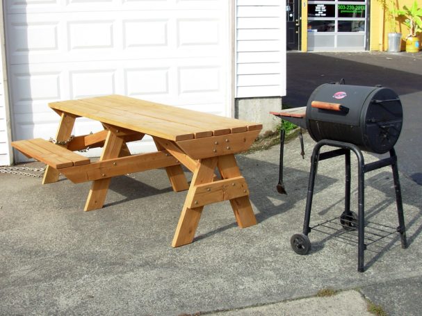 7' Commercial quality Custom Eco Outdoor Hybrid Bench Picnic Table with an extended table slanted right next to a grill.
