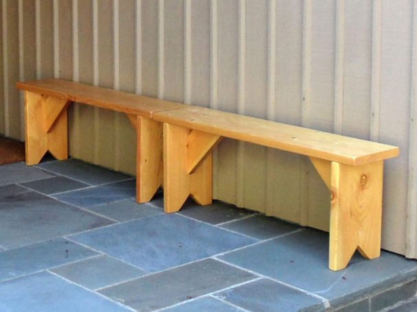 Two Commercial quality eco-friendly Outdoor Farmhouse Bench slanted to the left on a patio.