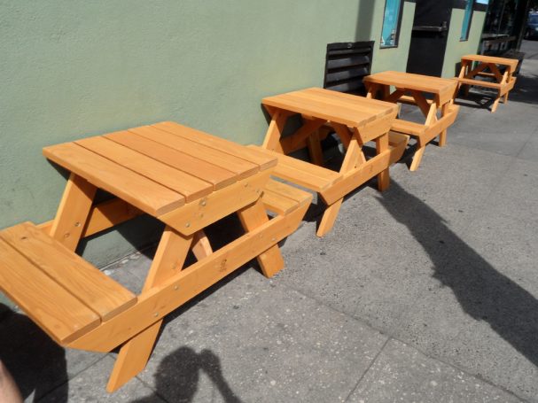 Small Commercial quality eco-friendly Outdoor Attached Bench Picnic Tables in a row at a restaurant bar.