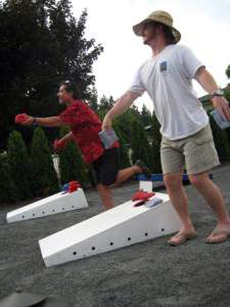Side of people playing a cornhole tournament on back-to-back sturdy high quality solid box design Cornhole Board Sets.