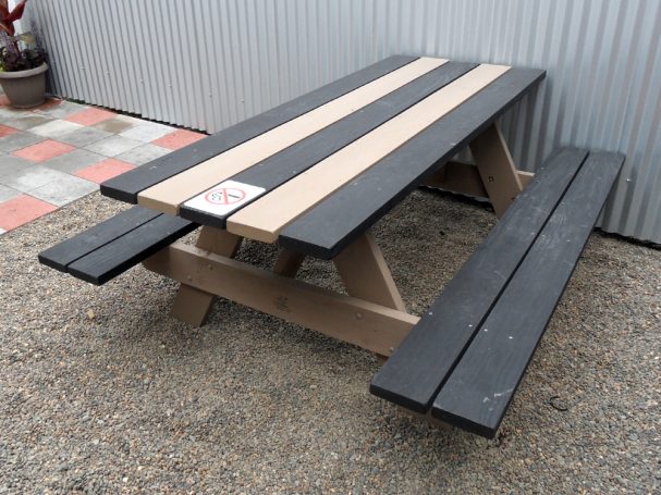 Striped black and gray Commercial quality eco Outdoor Attached Bench Picnic Table slanted right on restaurant bar patio.