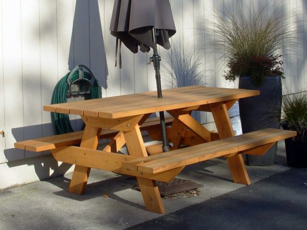 Commercial quality eco-friendly Outdoor Attached Bench Picnic Table with umbrella slanted to the right in a break area.