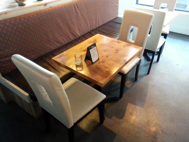Commercial quality Handcrafted Juniper Table Top dining table slanted to the right at a restaurant bar.