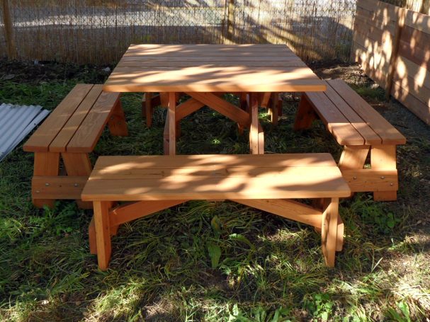 Commercial quality Eco-friendly Outdoor Square Detached Bench Picnic Table with four benches from the front in backyard.
