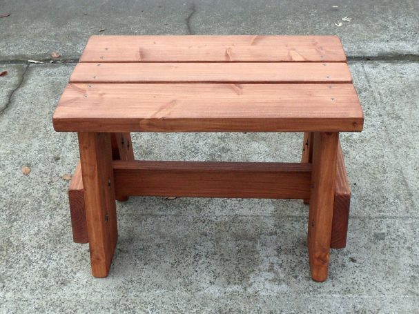 Front view of a Commercial quality eco-friendly Outdoor Picnic Table Bench on the sidewalk.