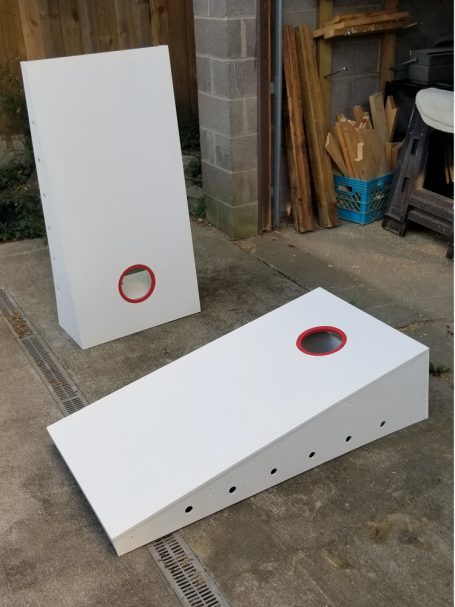 Side of a set of two sturdy high quality solid box design Cornhole Boards one standing up and one lying flat.