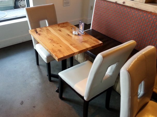 Commercial quality Handcrafted Juniper Table Top dining table slanted to the left at a restaurant bar.