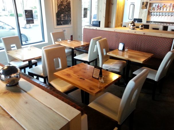 Dining tables with commercial quality Handcrafted Juniper Table Tops inside a restaurant bar.