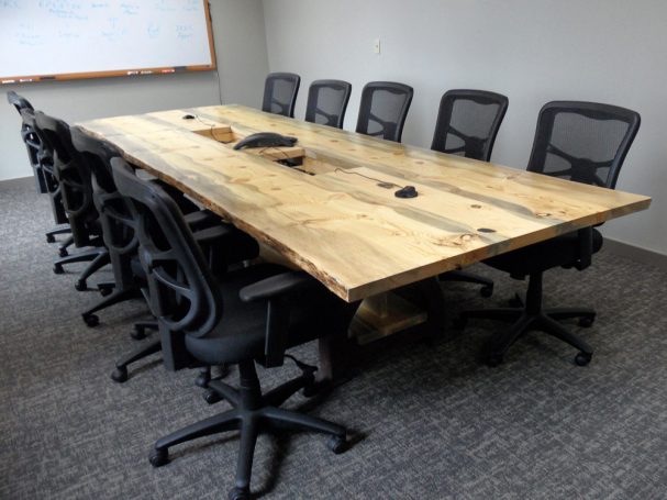 Back of a Custom Live Edge Blue Pine Slab Conference Table with reclaimed antique machinery bases slanted to the right.