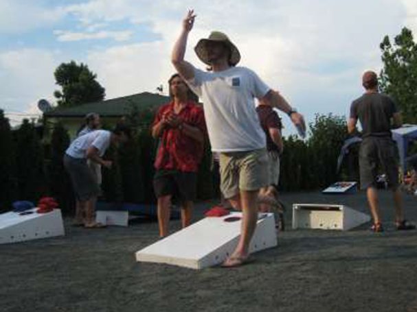Front of people playing a cornhole tournament on back-to-back sturdy high quality solid box design Cornhole Board Sets.
