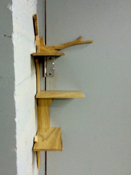 View of the right side of a Handcrafted Poplar Bird and Tree Corner Shelf hanging in the corner.