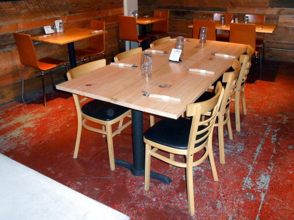 Large commercial quality Maple Table Top dining table slanted to the right at a restaurant bar.