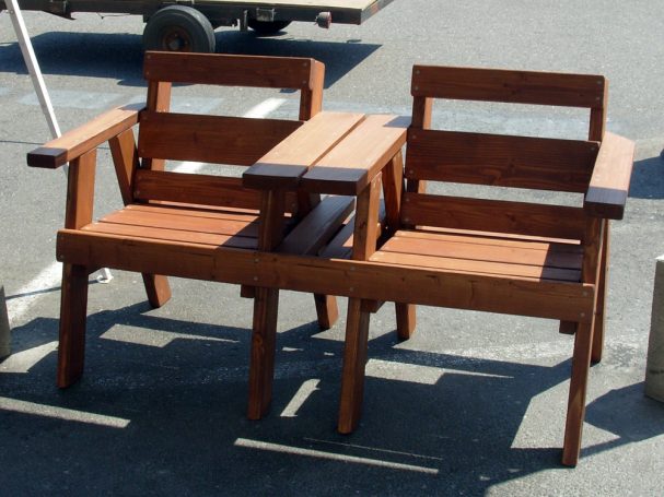 Front view of a 5' Commercial quality eco-friendly Outdoor Park Bench with a center table at a restaurant bar.