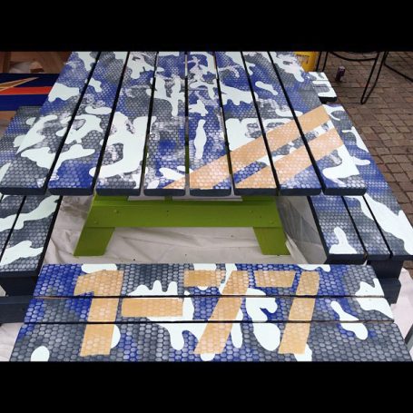 Painted Commercial quality Eco Outdoor Square Detached Bench Picnic Table with four benches from the front at an event.