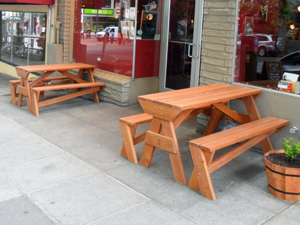 Two Commercial quality Custom Eco-friendly Outdoor Hybrid Bench Picnic Tables on a restaurant bar sidewalk.