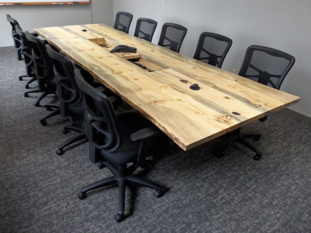 Luxury Live Edge Blue Pine Slab Conference Table with reclaimed antique machinery bases slanted to the right.