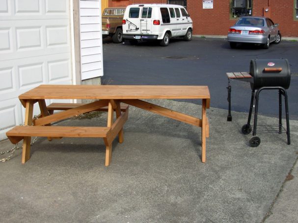 Side of a 7' Commercial quality Custom Eco Outdoor Hybrid Bench Picnic Table with an extended table next to a grill.