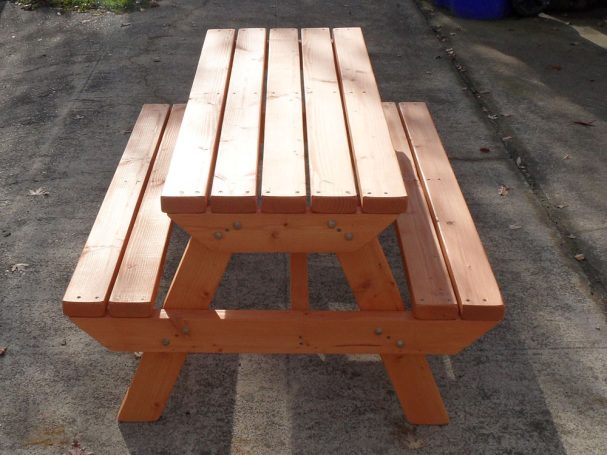 4' Commercial quality Eco-friendly Outdoor Kids Attached Bench Picnic Table from the front on a sidewalk.