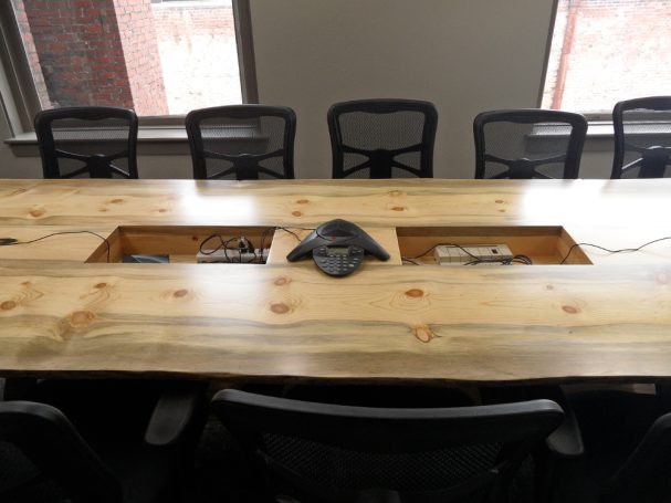 Side of a Custom Live Edge Blue Pine Slab Conference Table with reclaimed antique machinery bases.