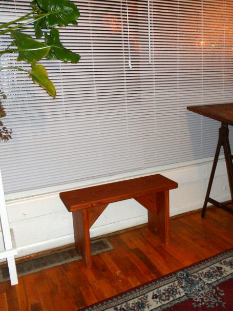 Commercial quality eco-friendly Outdoor Farmhouse Bench slanted to the right in a house.
