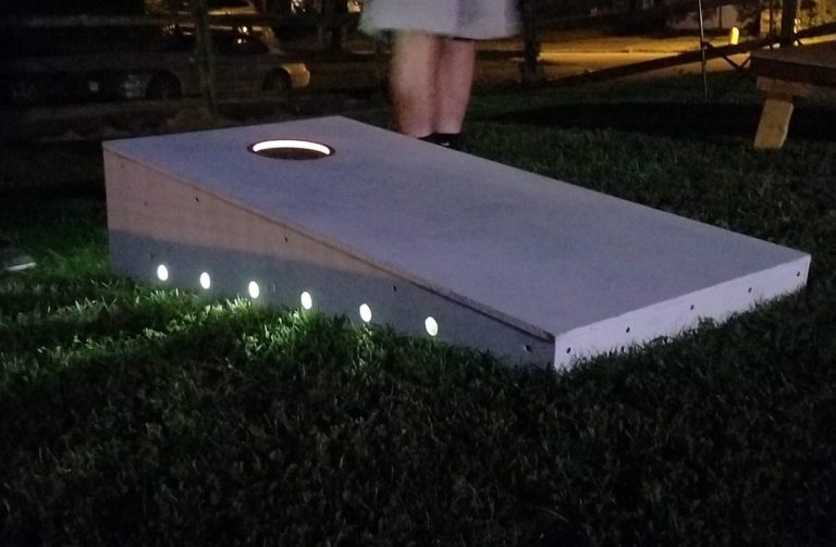 Sturdy high quality solid box design Cornhole Board in a yard over a light to play at night.
