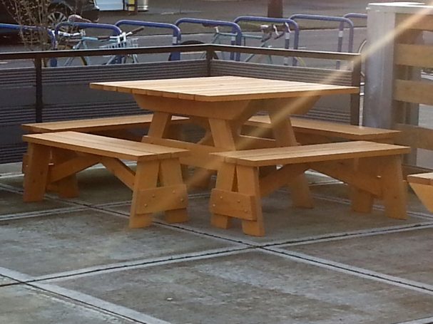 Commercial quality Eco Outdoor Square Detached Bench Picnic Table with four benches slanted on a restaurant bar patio.