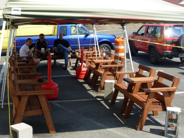 5' Commercial quality eco-friendly Outdoor Park Benches with center tables slanted to the left at a restaurant bar.