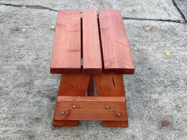 Side view of a Commercial quality eco-friendly Outdoor Picnic Table Bench on the sidewalk.