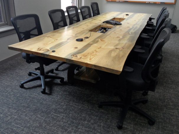 Luxury Live Edge Blue Pine Slab Conference Table with reclaimed antique machinery bases slanted to the left.