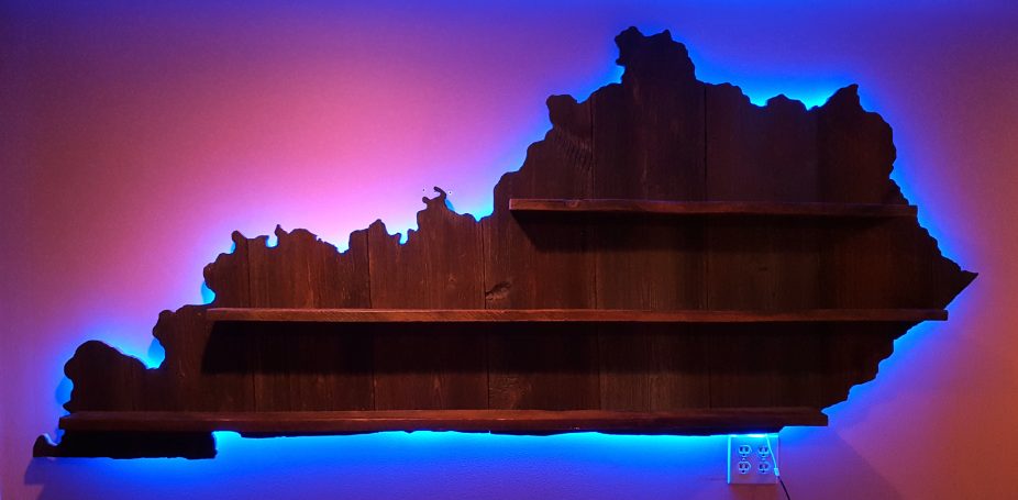 Backlit Handcrafted Barnwood Kentucky Derby Glass Shelf without glasses hanging flat on a wall.